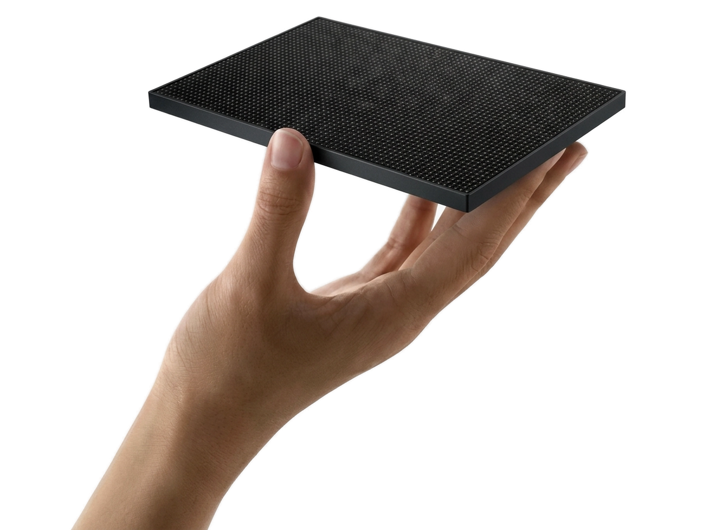 Hand presenting a black LED video wall tile module with matte black border